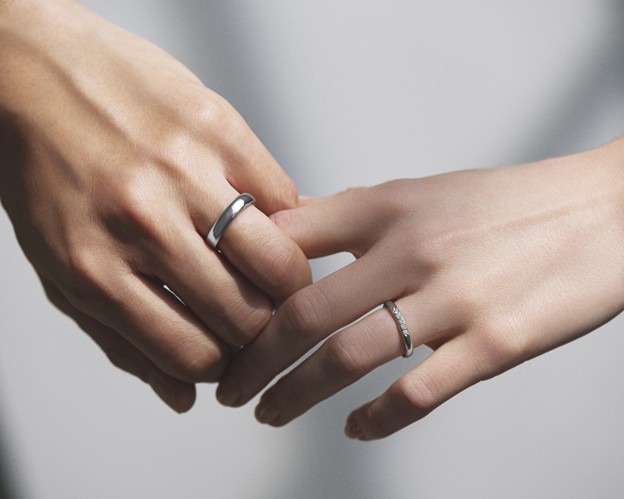 Hands holding I-PRIMO platinum rings